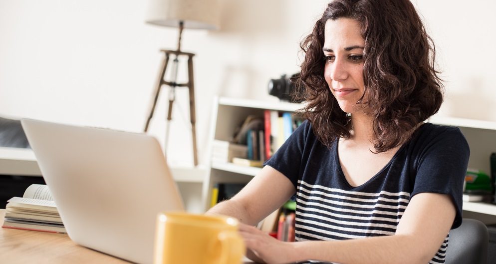 imagem de mulher sentada em frente ao notebook, criando a proposta de valor de um negócio