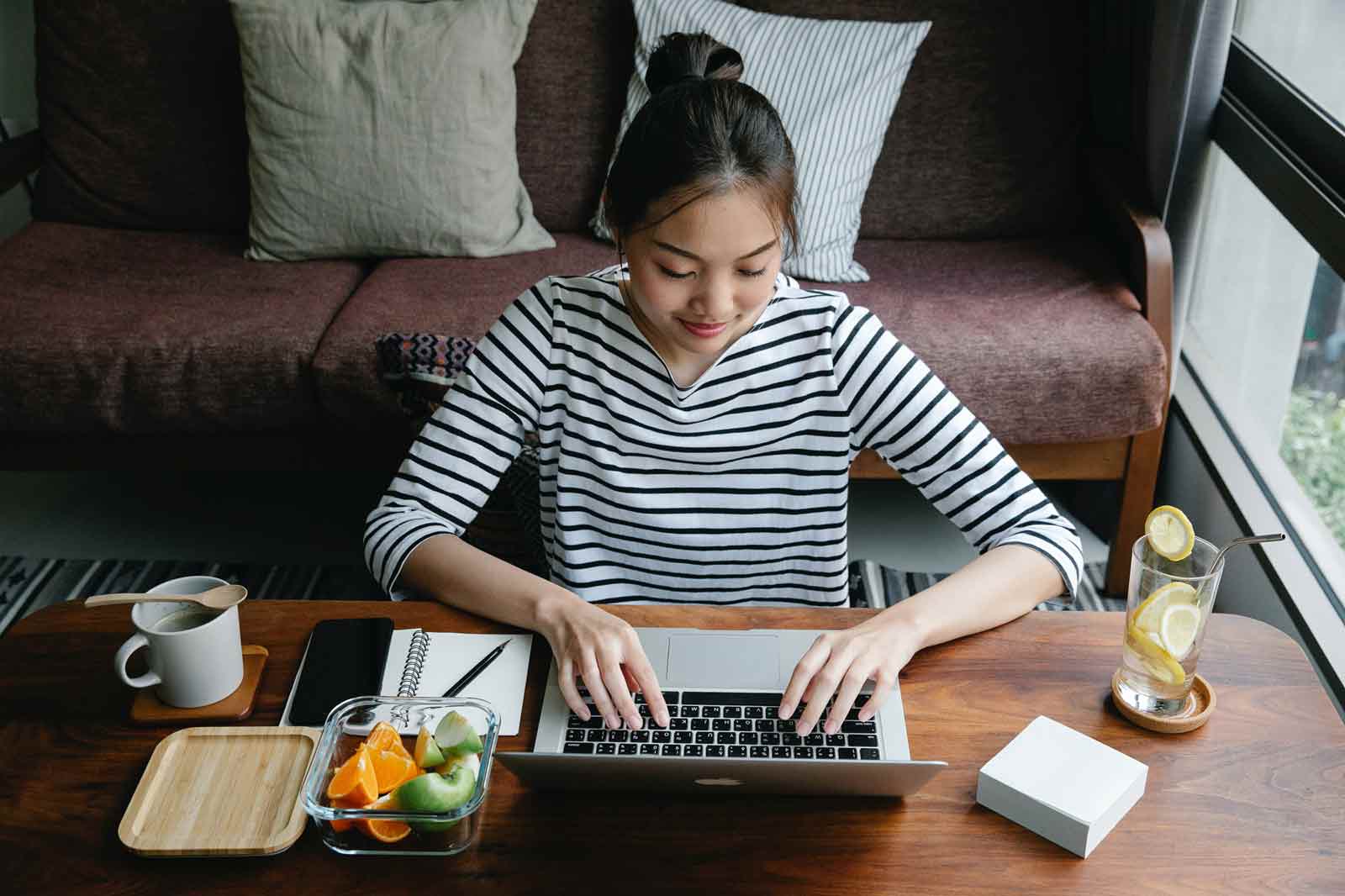 Mulher verifica como montar uma loja virtual em seu notebook