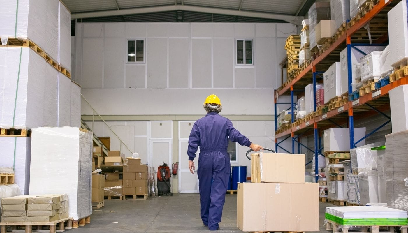 homem carregando caixas em um armazém, representando a logística reversa no e-commerce