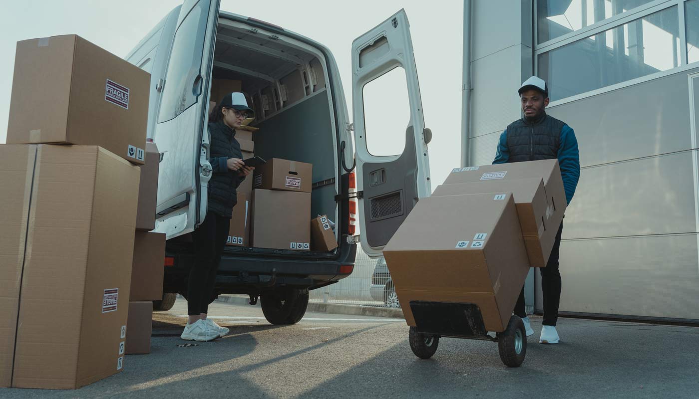 Funcionários carregam caixas para transporte depois de utilizar o sistema TMS